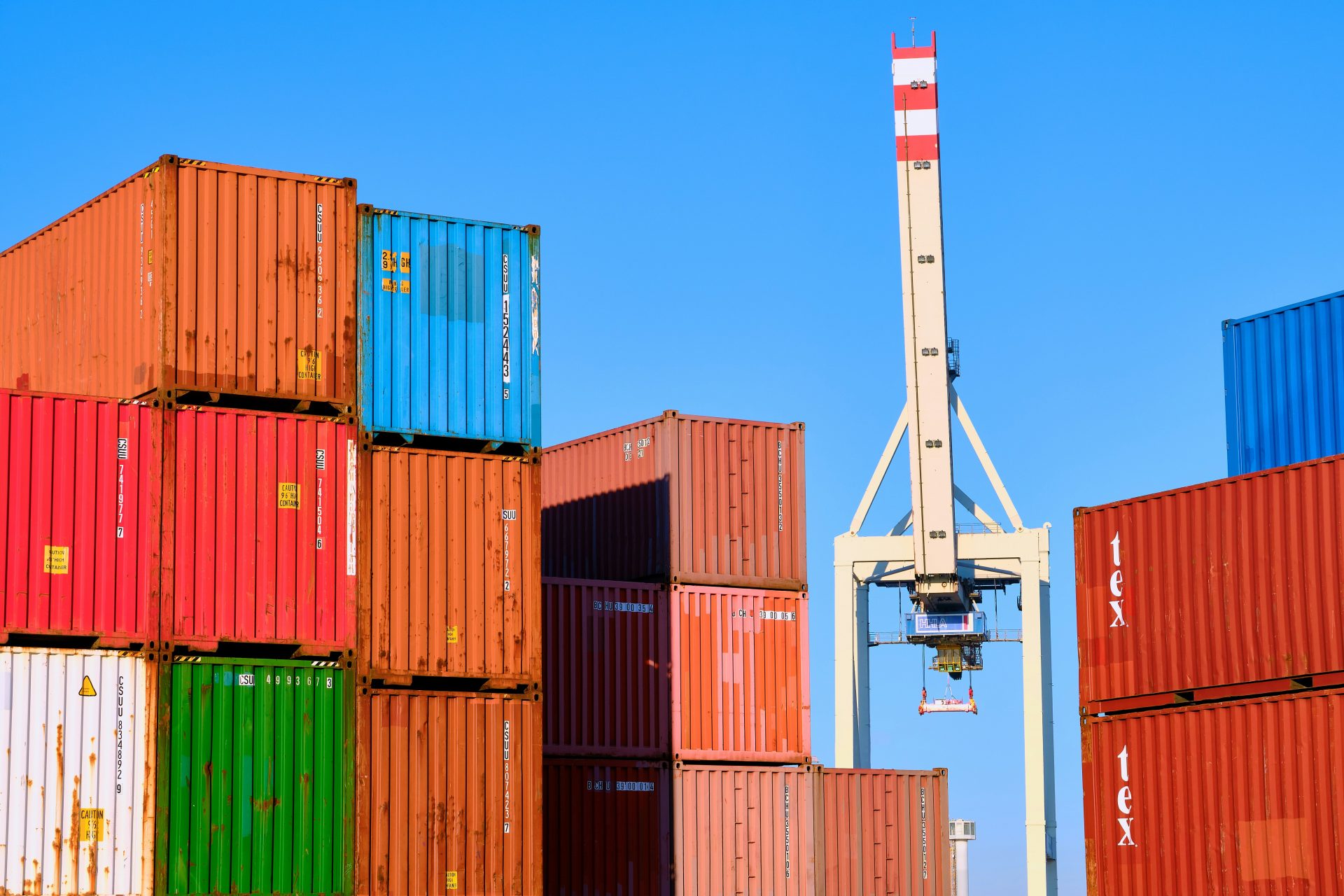 stack of cargo containers with white crane